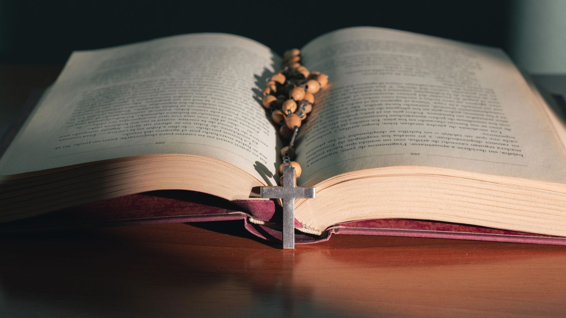Cross on the holy bible on a wooden table